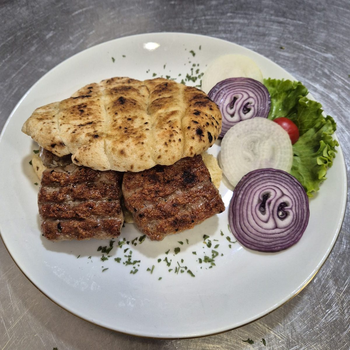 Banjalučki ćevap u lepinji — Banja Luka ćevapi in lepinja, with onion