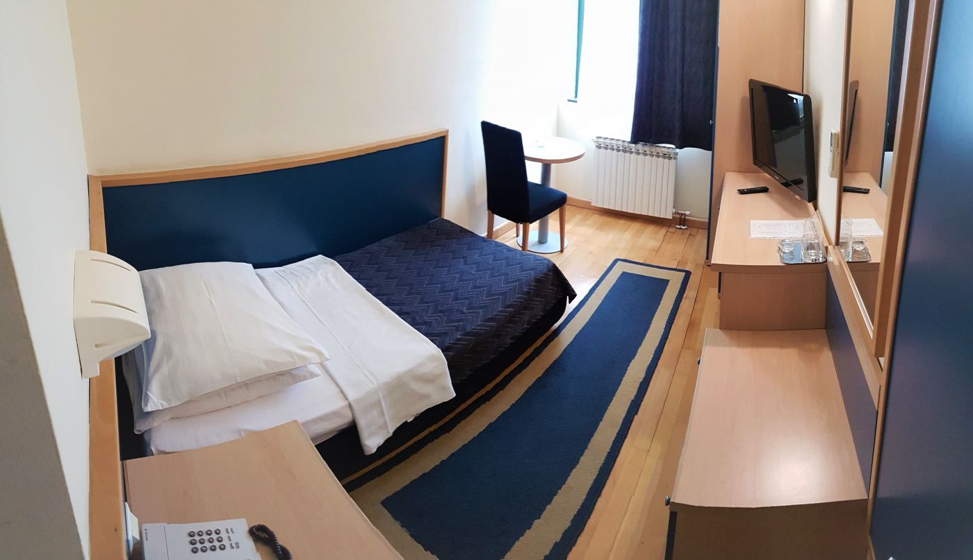 Single room with bed, TV, desk and seating